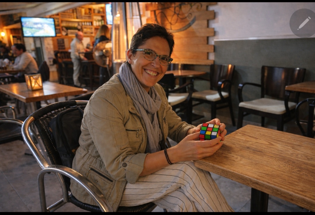 s’amuser en solo cliente souriante jouant en solo avec un Rubik's cube
